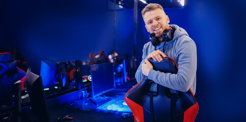 Portrait happy young man streamer professional gamer of online games with headphones, neon color banner © Parilov