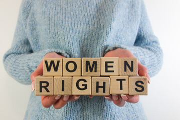 Woman holding text women rights from wooden blocks