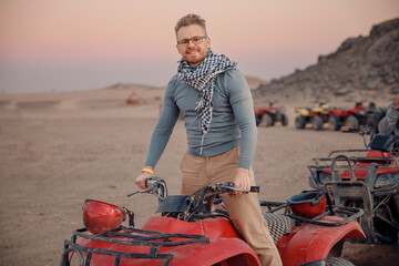 Man tourist with arafatka on quad bike ATV safari in desert Arab Emirates, Egypt © Parilov