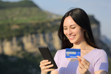 Fototapeta premium Asian woman buying online with credit card in nature