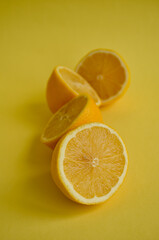juicy lemons cut in half arranged in a line on a soft yellow background