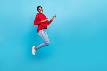 Fototapeta premium Full size photo of jumping beautiful appearance girl in stylish casual clothes promote sale discount isolated on blue color background