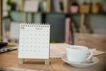 Calendar Year and, cup of coffee place on business office desk. Agenda for organizer to plan timetable, daily appointment, and management job at room. Calendar and Planner Concept.