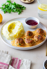 Swedish meatballs in cream sauce, potatoes and lingonberry sauce. Swedish cuisine. Recipe.