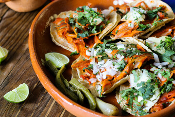 Mexican tacos al pastor accompanied by vegetables and sauces