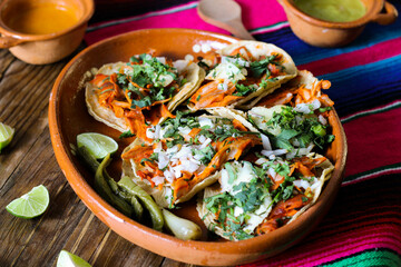 Mexican tacos al pastor accompanied by vegetables and sauces