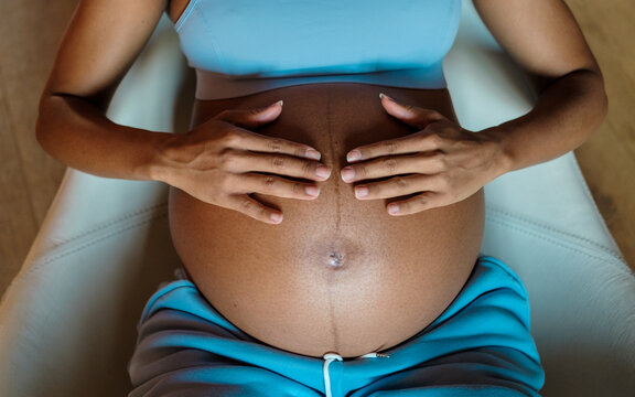 Pregnancy concept. Detail of pregnant woman hands touching her belly.