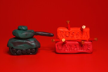 A toy tank and the inscription Russia, Ukraine on a red background.