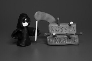 A figure of death with a scythe and the inscription Ukraine and Russia on a black and white...