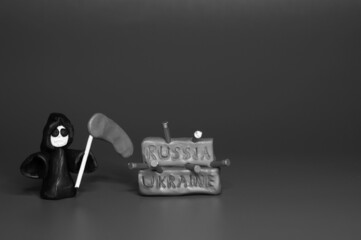 A figure of death with a scythe and the inscription Ukraine and Russia on a black and white background.