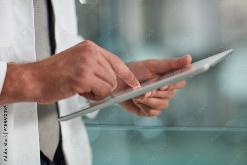 Poster tracking a patients progress. closeup shot of an unrecognisable doctor using a digital tablet.