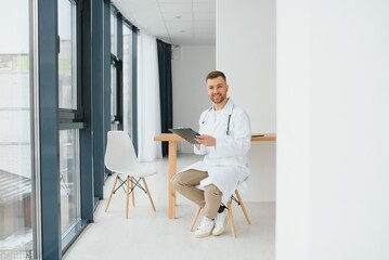 Male doctor near reception desk in clinic