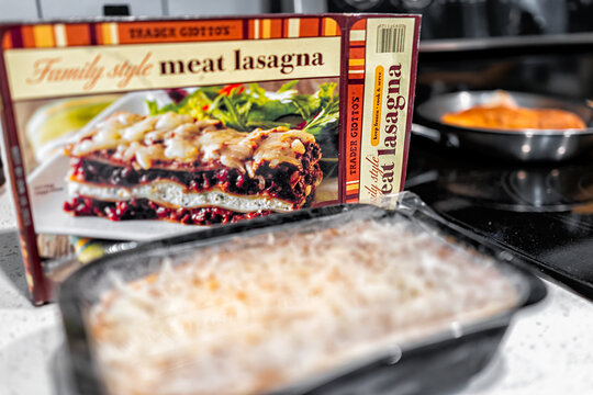 Naples, USA - August 28, 2021: Trader Joe's Italian Family Style Meat Lasagna package with frozen tv dinner tray for oven baking