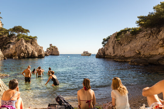 Baignade dans une crique de la m&eacute;diterran&eacute;e, la calanque de Sugiton en automne devant un bateau de touristes. Marseille en Provence, France