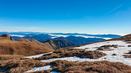 An alpine meadow covered by snow which is melting on a sunny spring day getting ready for the new season.View on The Ennstal Alps from mount Eisenerzer Reichenstein in Styria,Austria,Europe.Wanderlust