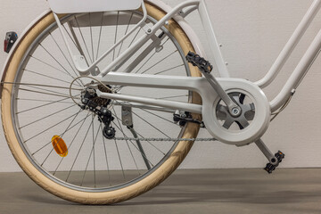 Close up view of back wheel of white bicycle with protection for clothes on chain. Sweden. 