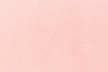 Sample of a texture of pink plaster. Wall finished with a decorative cement stucco. Example of exterior building decoration. Clean uniform grainy background. Banner. Wallpaper. Copy space. Pattern