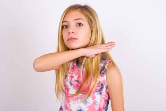 little caucasian kid girl wearing sport clothing over white background cutting throat with hand as knife, threaten aggression with furious violence.