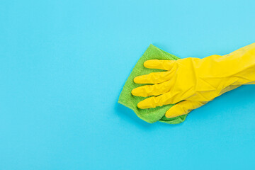 worker's hand in yellow rubber protective glove with micro fiber green sponge or washcloth. A maid or housewife takes care of the house. general or regular cleaning. .