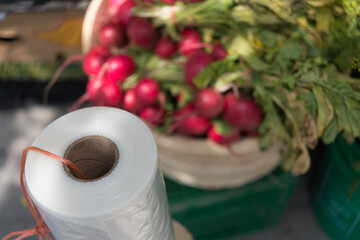  roll of clear plastic bags at the market (in the background: radishes)