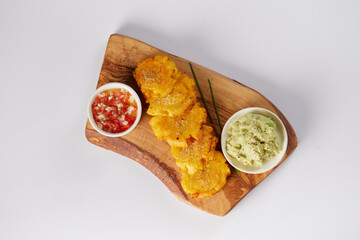 Patacones or tostones, typical Ecuadorian appetizer that consists on fried green plantain slices....