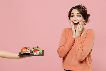 Young amazed satisfied fun woman 20s in casual clothes waiter hand hold giving makizushi sushi roll...