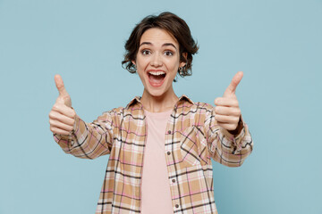 Young smiling satisfied fun european woman 20s wearing casual brown shirt showing thumb up like...