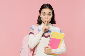 Teen student girl of Asian ethnicity in sweater backpack hold books say hush be quiet with finger...