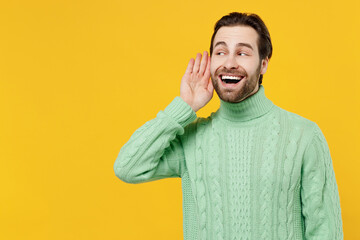 Young smiling curious nosy happy man 20s wear mint knitted sweater try to hear you overhear...