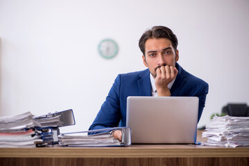 Young male employee and too much work in the office