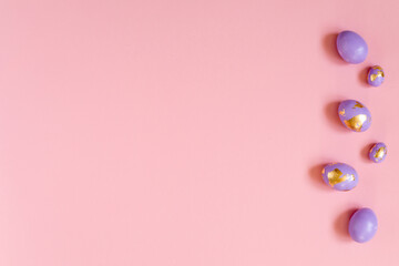 Easter background, violet, very peri eggs with golden foil on the pink background. 