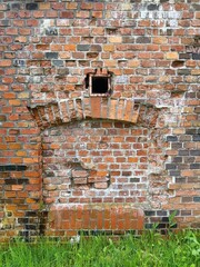  wall of old bricks on green grass