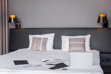 devices and documents on bed in hotel room