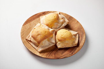 Homemade Ecuadorian quesadillas, a traditional pastry served on a wooden plate with a white background 