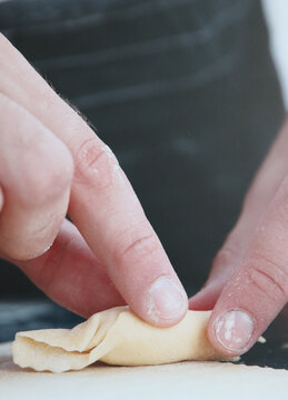 cook closing a stuffed pasta tortello -