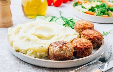 Turkey patties served with mashed potato and fresh salad
