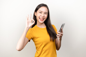 Fototapeta premium Happy asian woman holding smartphone and showing hand sign ok isolated on background