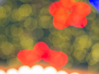 Abstract blurry vivid red color star shape on green and yellow bokeh, glitter for pattern, texture and background