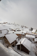 Alpe d'Huez- france. 15-02-2022. The famous ski town of Alpe d'Huez in the French Alps. Wooden houses are covered with snow and fog in the morning.