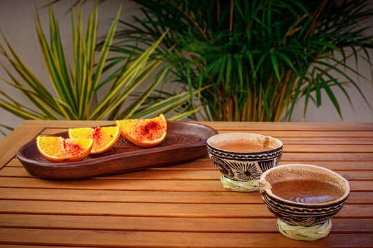 Mezcal en jicara y naranjas