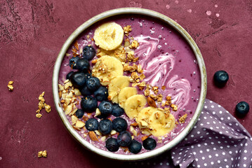 Banana blueberry smoothie bowl for a breakfast. Top view with copy space.
