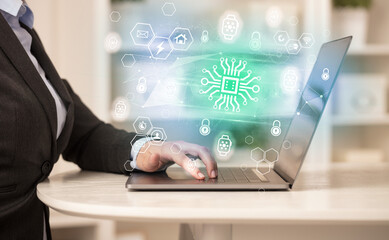 Hands working on laptop with digital icons