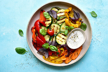 Grilled vegetables with yoghurt sauce. Top view with copy space. Top view with copy space.