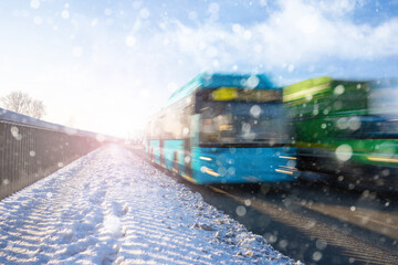 Bus moving on the road in city in sunny winter day. View to the public transport.