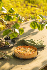 Golden organic healthy crispy pie with artichokes, dried tomatoes and olives on the table