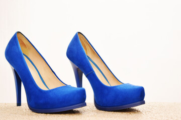 Zapatos azules de tacón alto para mujer. Calzado formal, para fiesta o trabajo sobre un fondo blanco. Espacio para texto al lado derecho.