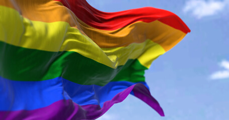 the rainbow flag waving in the wind in a clear day