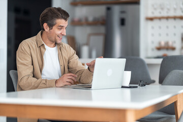 Fototapeta premium Happy male entrepreneur having a video call from home office.