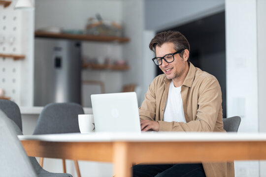 Happy businessman surfing the Internet on a computer while working at home.