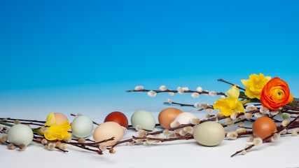 Osterdekoration mit bunten, natürlich farbigen Eiern, arrangiert mit Weidenkätzchen und...